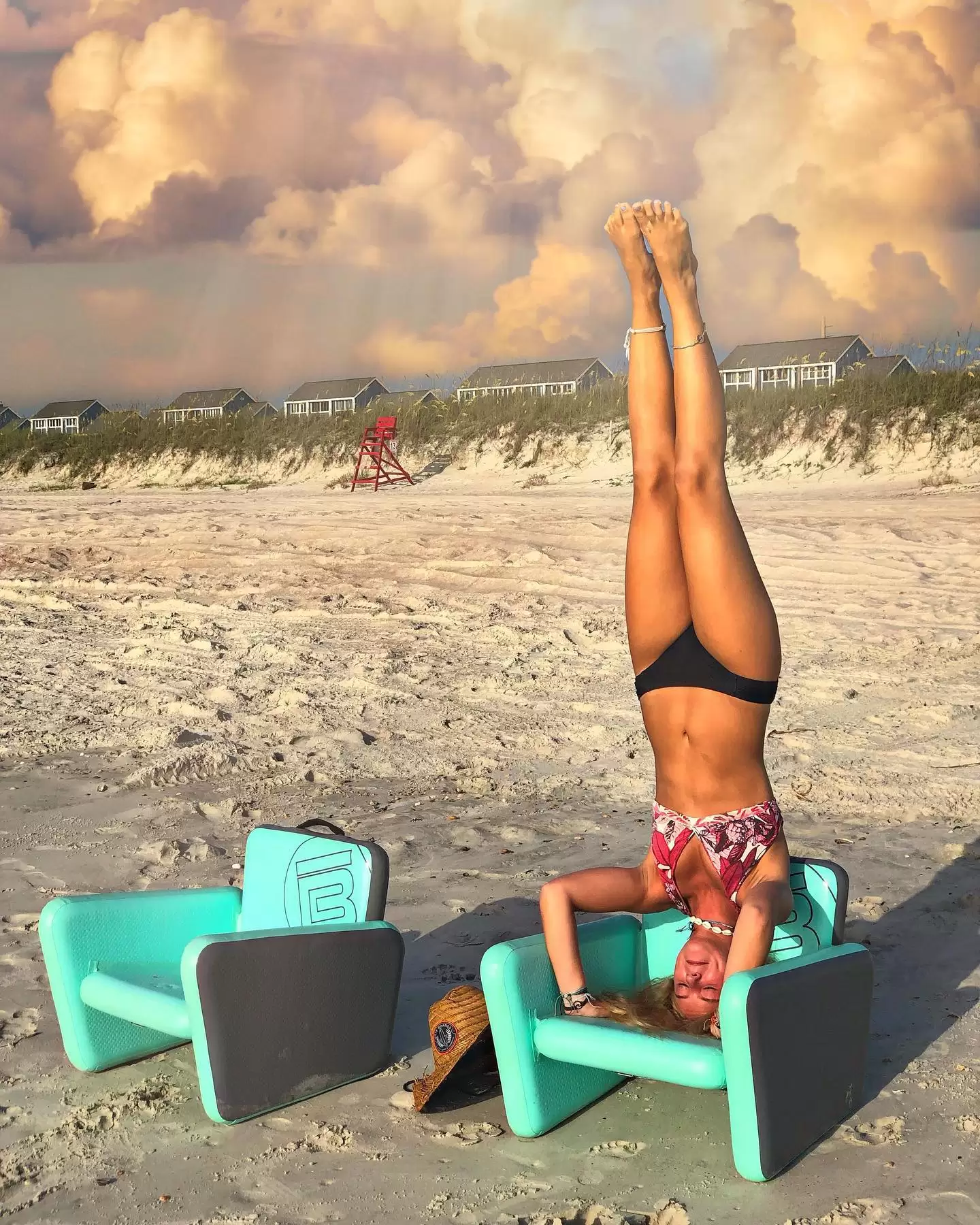 BOTE Aero Chair on the beach with a girl doing a headstand on it.